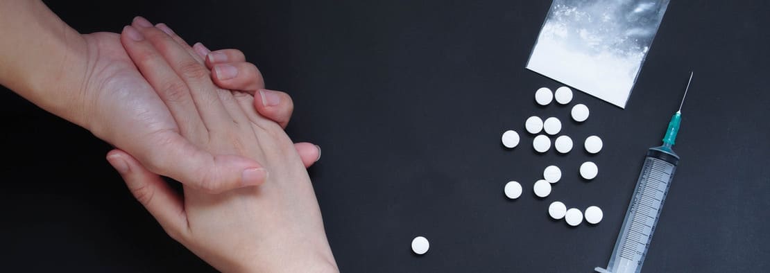 Две руки и наркотические вещества на столе